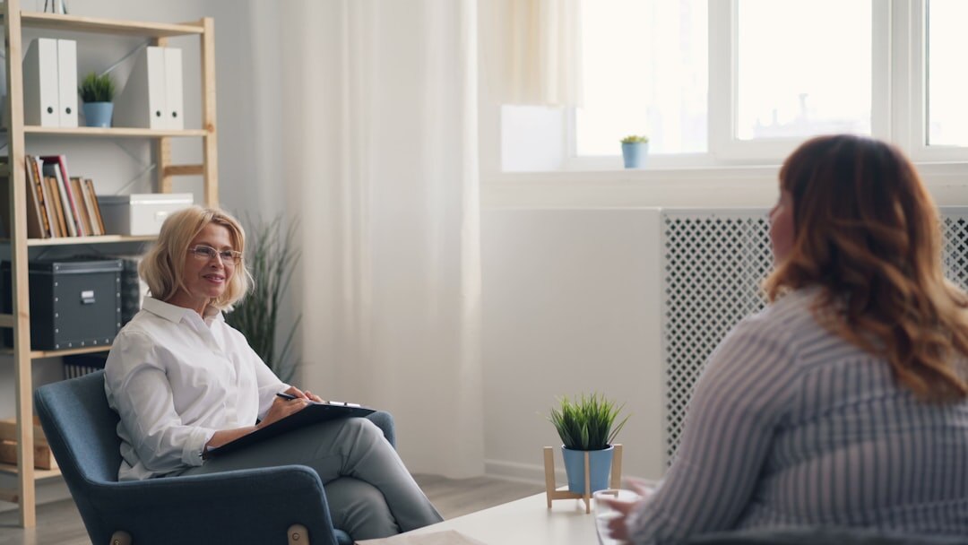 Photographer interviewing an elderly Danish woman at her kitchen table